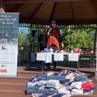 A loon calling competition contestant performs on a gazebo