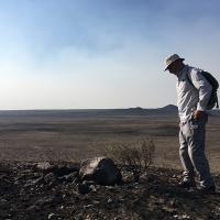 Michael Schroeder looking at sagebrush devastated by wildfire