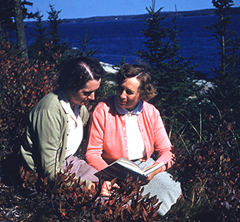Rachel Carson and Dorothy Freeman sitting outdoors reading a book
