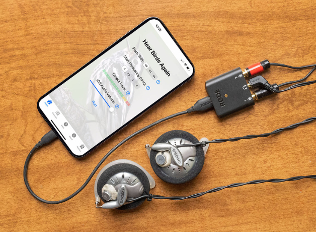 Smartphone lays face up with cables and headset connected